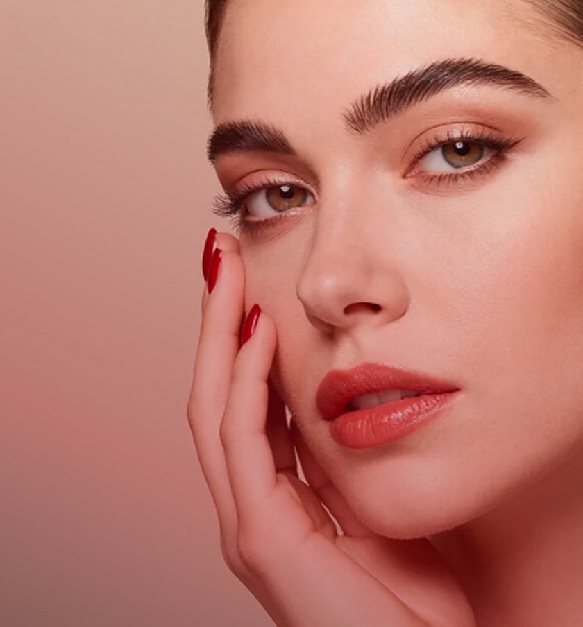 Mujer con cejas definidas y uñas color cereza